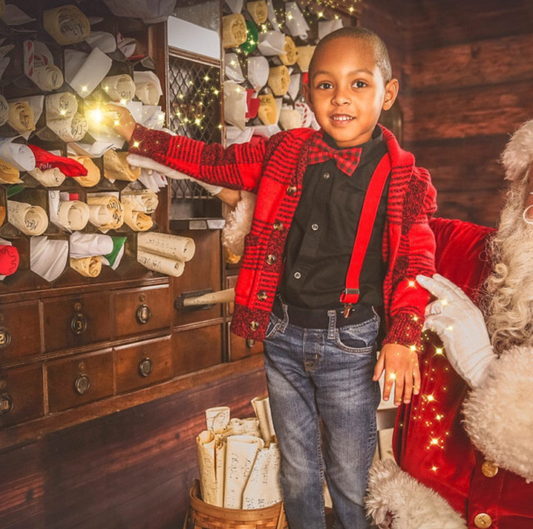 Child in a festive setting with Santa Claus, surrounded by Christmas decorations.