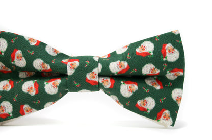 Green bow tie with vintage Santa Claus pattern on a white background