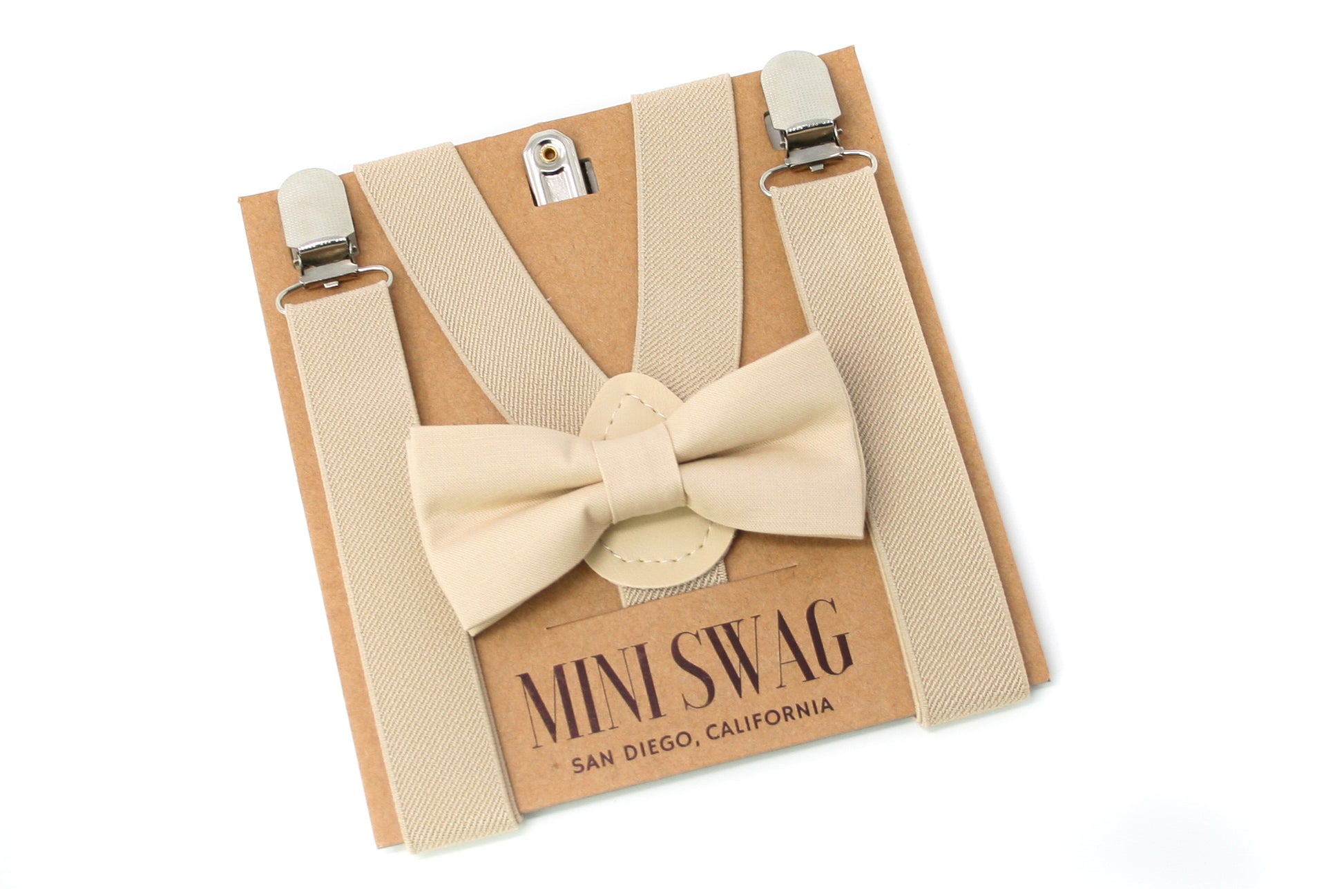 Beige bow tie and suspenders set on a 'Mini Swag' branded box.