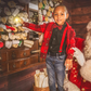 Child in a festive setting with Santa Claus, surrounded by Christmas decorations.