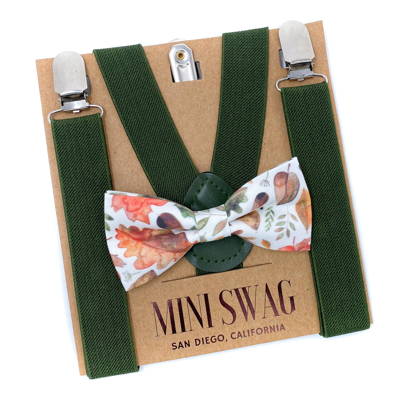 Green suspenders with a fall leaves bow tie on a cardboard backing, featuring 'Mini Swag' branding.