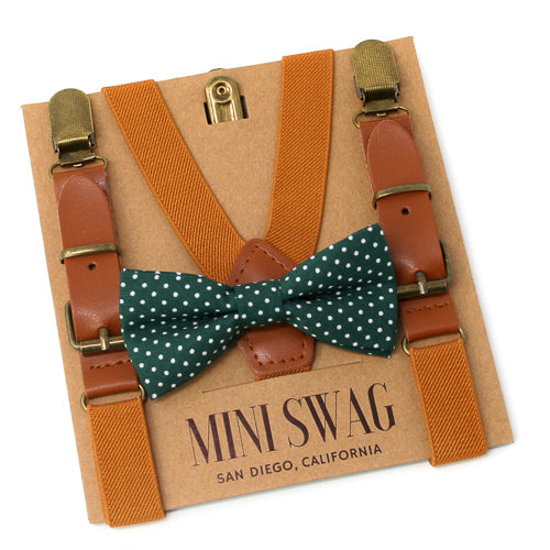 Brown suspenders with gold clips and a green polka dot bow tie on a 'Mini Swag' branded card.