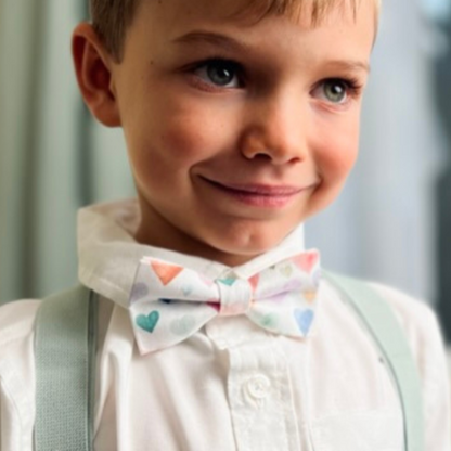 a young boy wearing a bow tie and suspenders