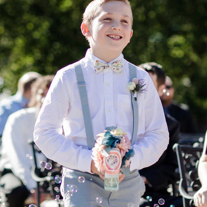 a young boy wearing a bow tie and suspenders