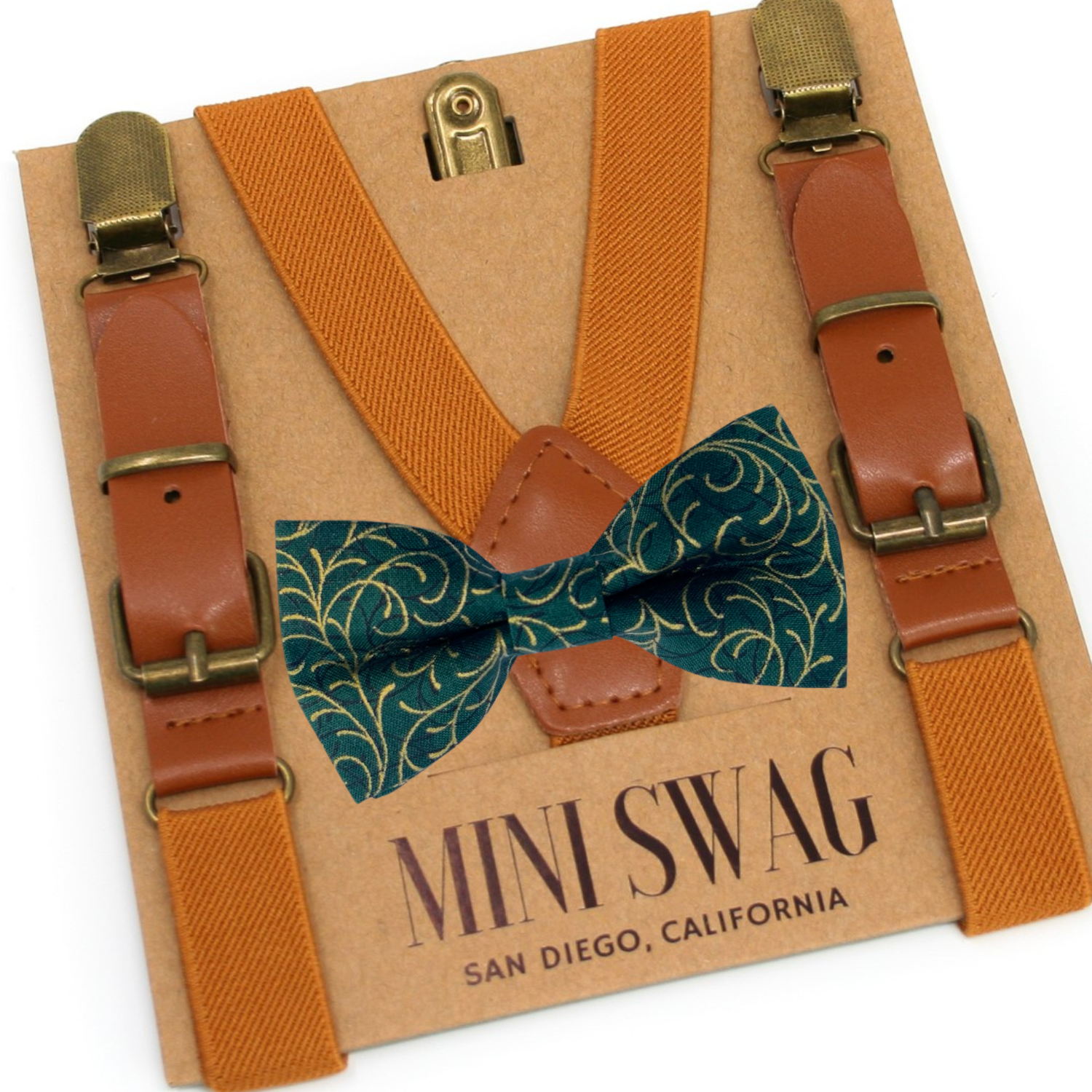 Camel Suspenders and green and gold swirl bow tie set with 'Mini Swag' branding on a cardboard backing.