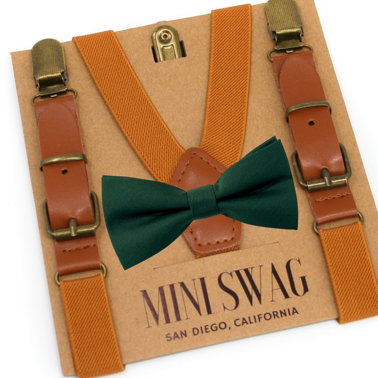 Camel leather buckle suspenders with gold clips and a green bow tie on a 'Mini Swag' branded card.