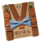 Brown suspenders with gold clips and a dusty blue  bow tie on a 'Mini Swag' branded box.