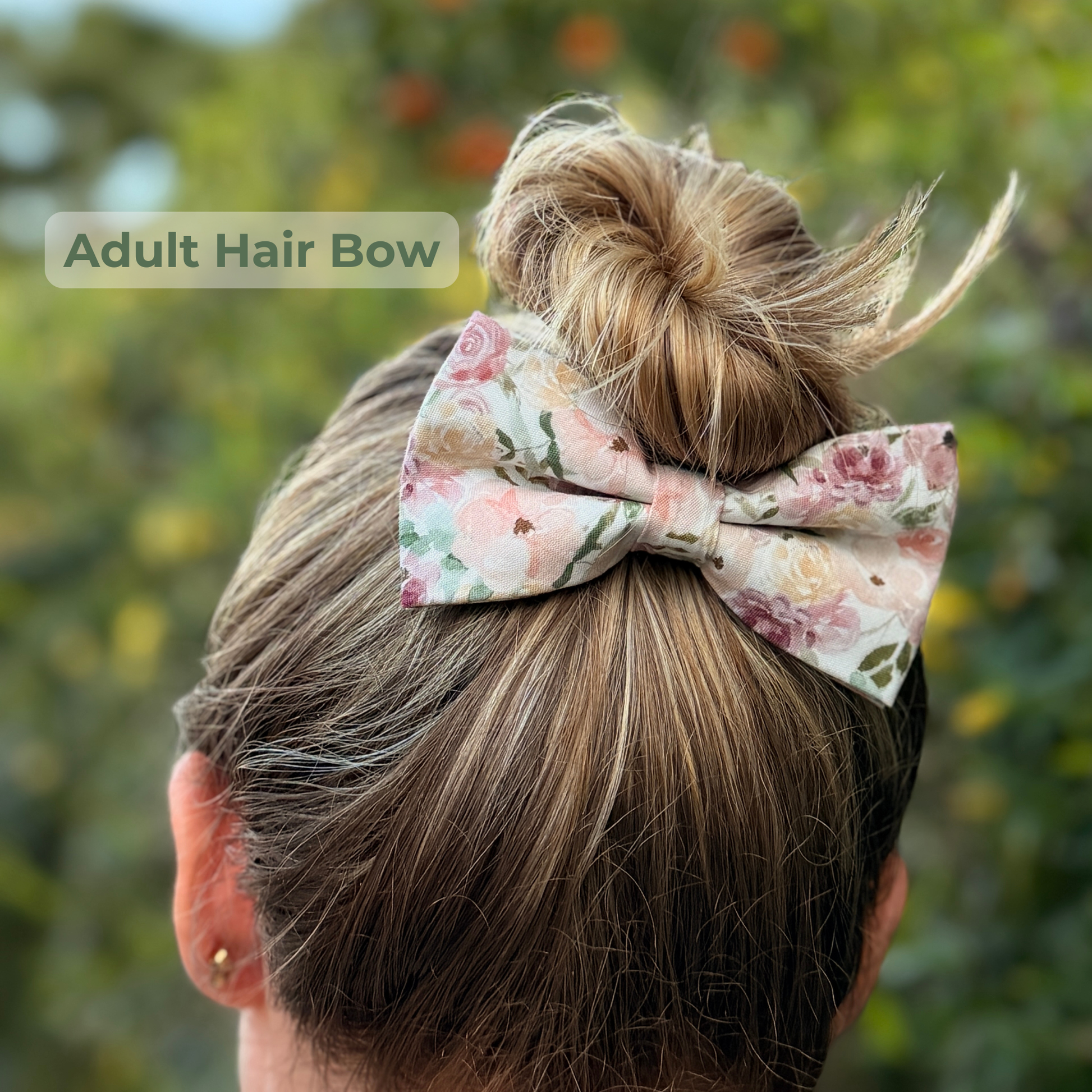 Floral hair bow on a bun with a blurred green background