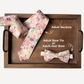 Floral necktie and bow tie set on a wooden tray with text labels.