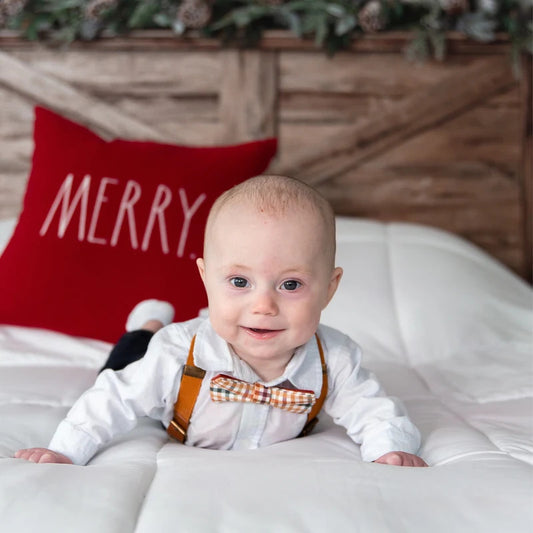 baby boy wearing fall plaid bow tie and camel leather buckle suspenders
