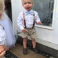 a little boy wearing a bow tie and suspenders