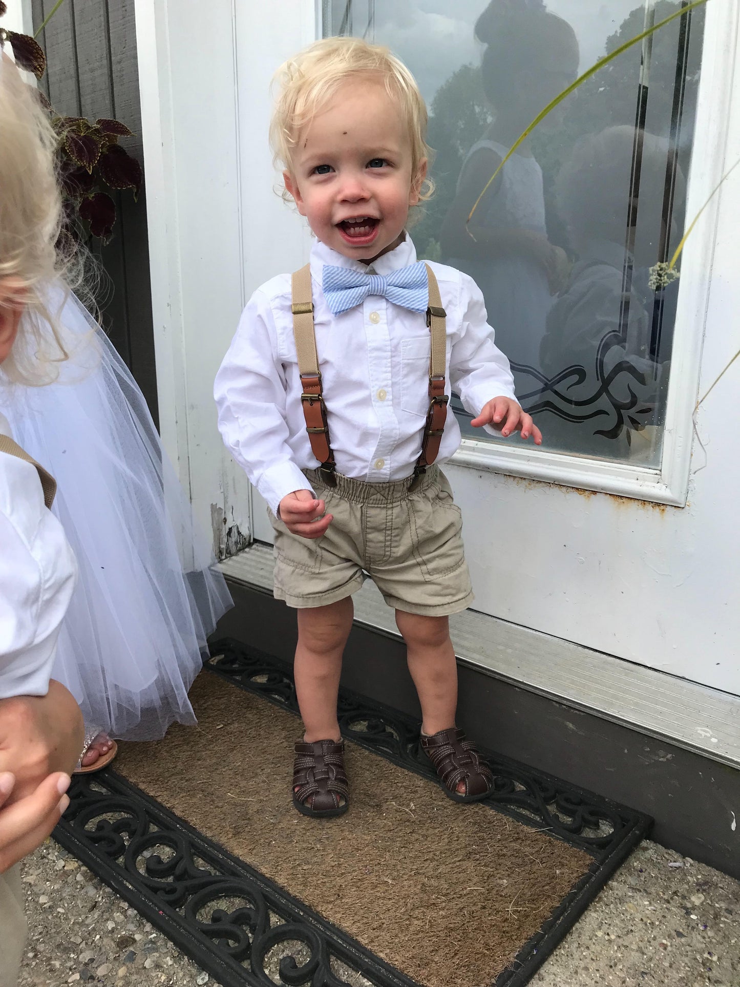 a little boy wearing a bow tie and suspenders