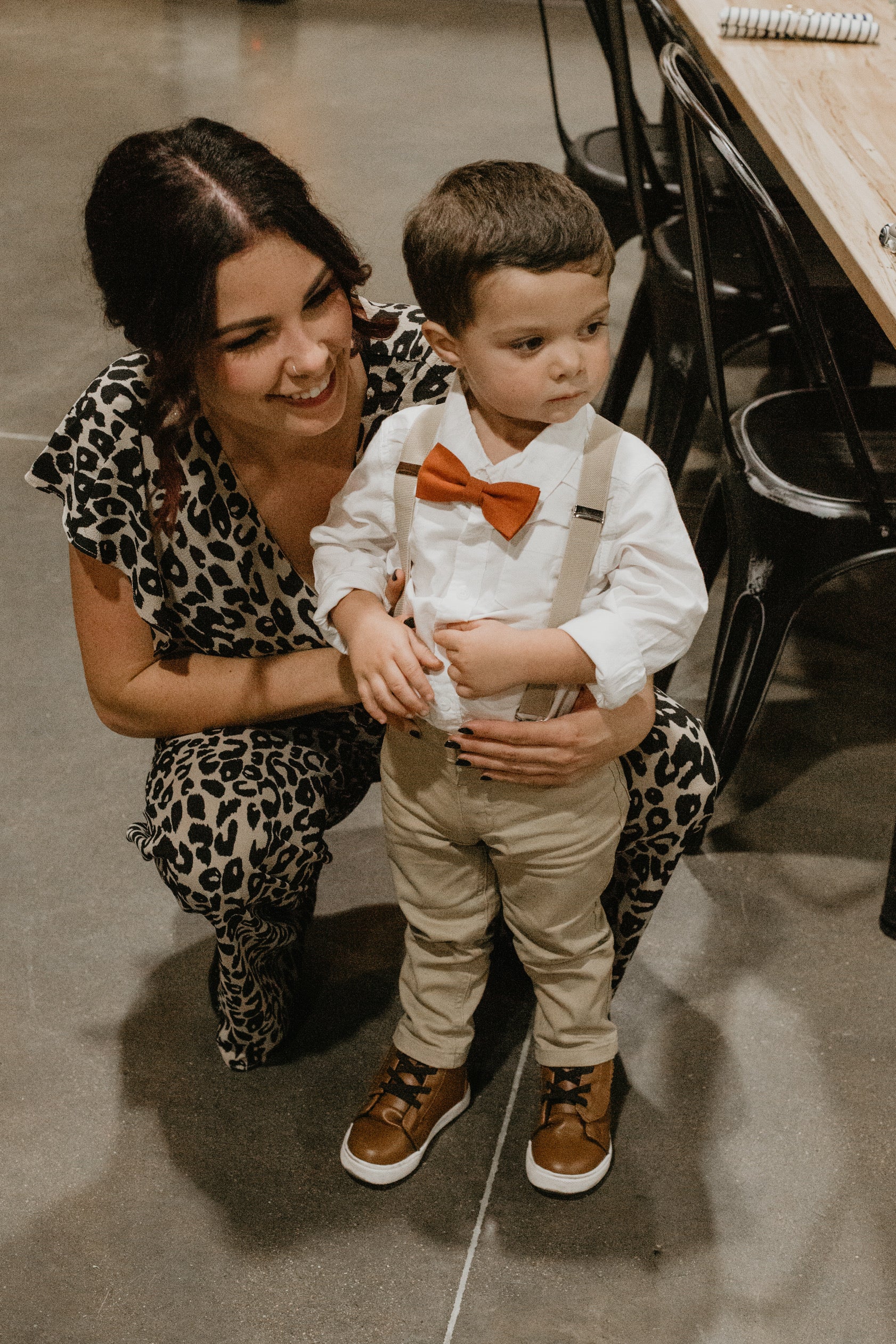 a woman is holding a small boy wearing a bow tie