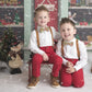 two young boys sitting on a bench in front of a christmas tree