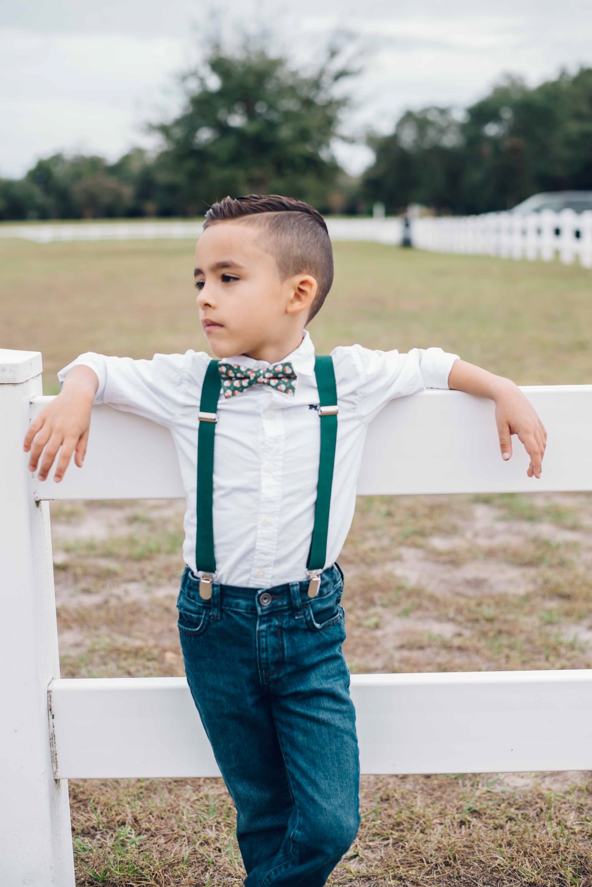 a young boy wearing suspenders and a bow tie