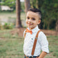 a young boy wearing a bow tie and suspenders