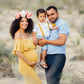 a man and woman holding a baby in a desert